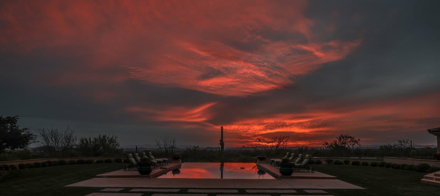 Arizona sunset reflecting over a clean backyard pool